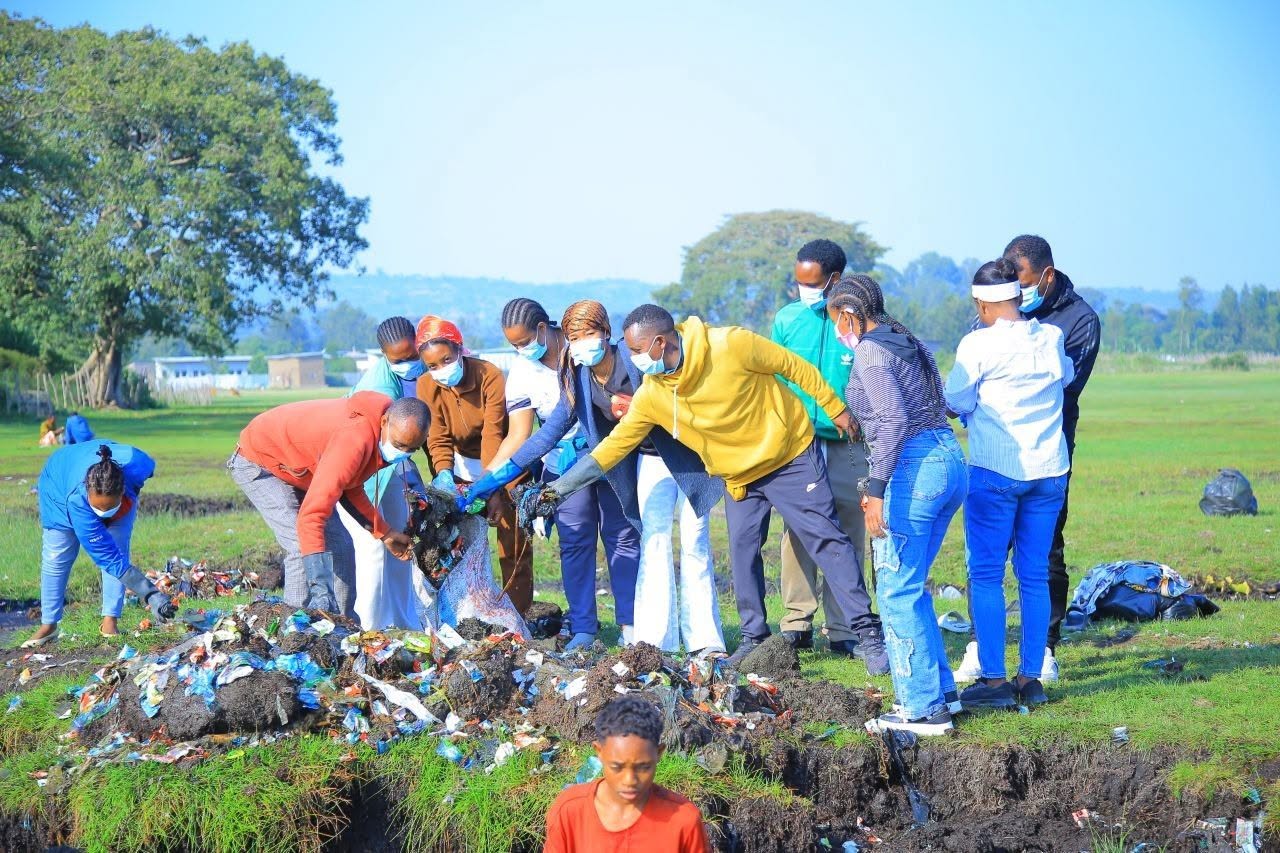 Young volunteers planting seedlings together in a field