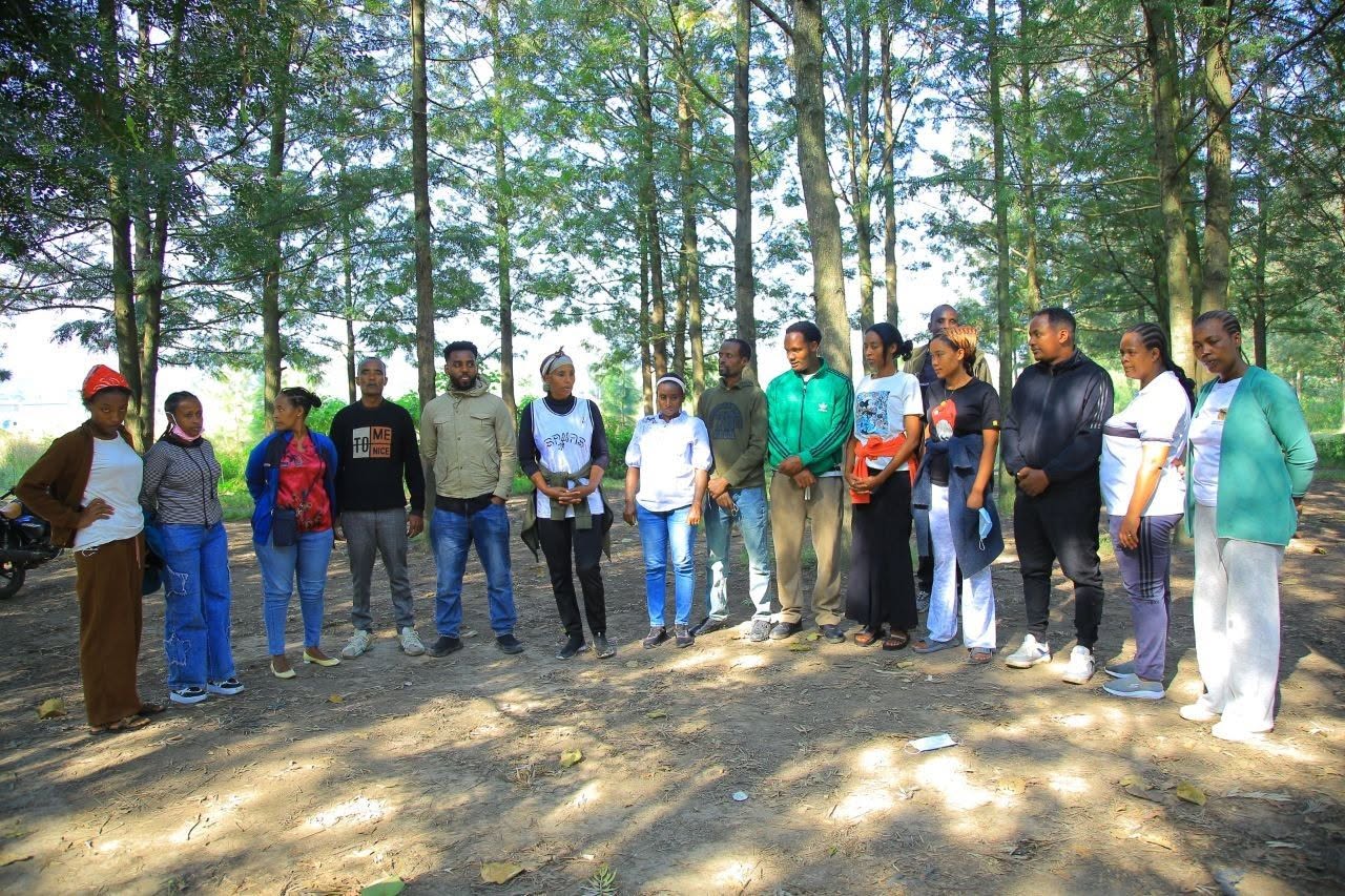GSI volunteers gathered in a wooded area for tree planting